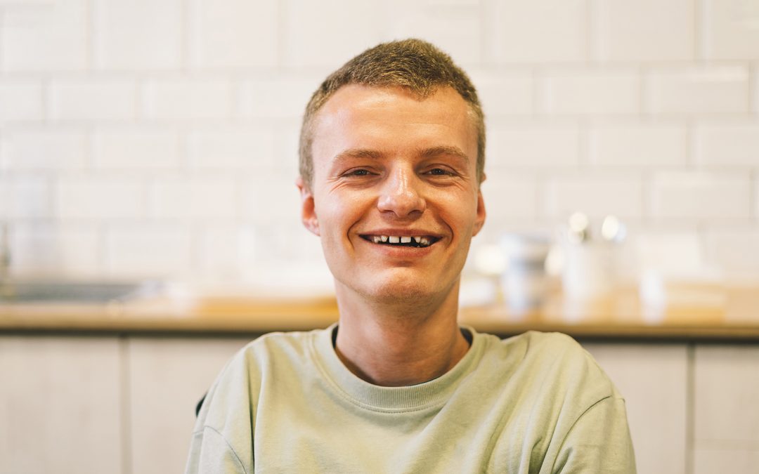 Portrait of young man with disabilities smiling.